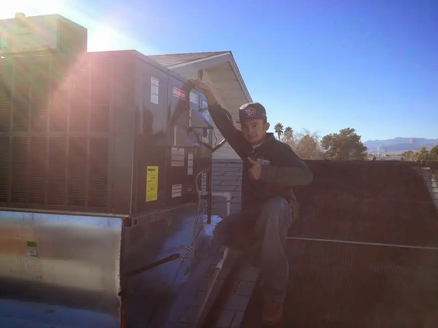 HVAC technician performing Boiler Repair on a rooftop unit in Piedmont